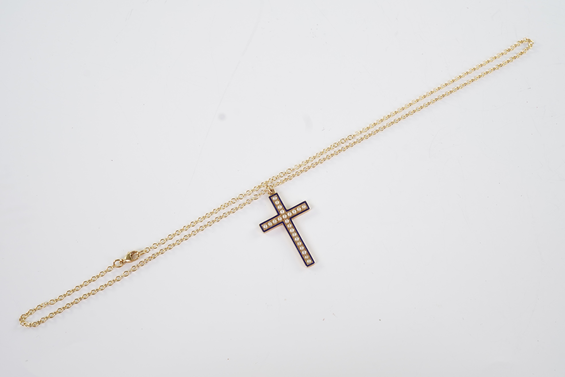 An Edwardian pearl and enamel cross and chain, early 20th century
